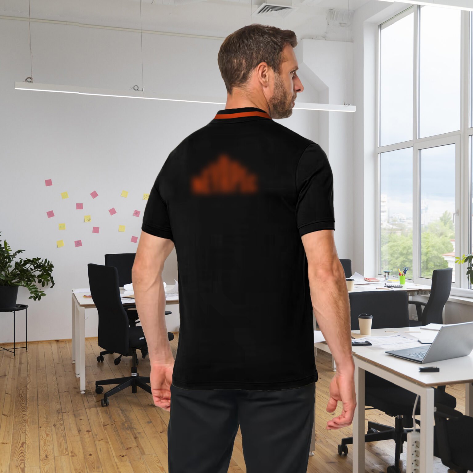 Collaborateur d'une entreprise en polo noir avec liseré orange et une broderie