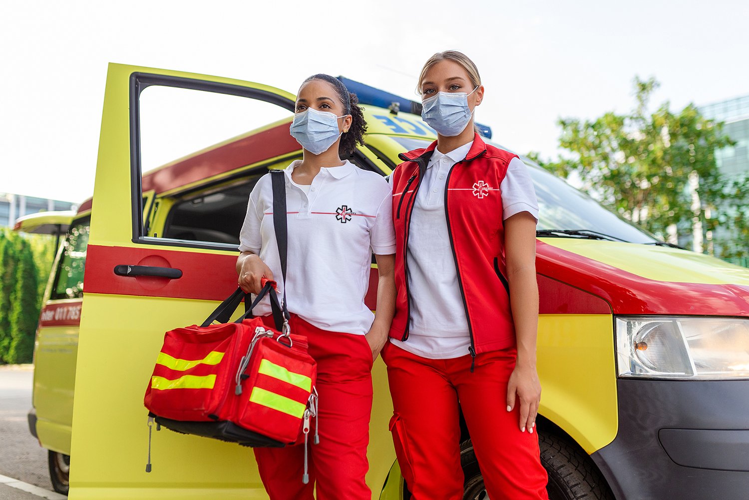 Ambulancières portant des uniformes aux couleurs de leur entreprise