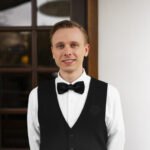 Serveur habillé avec un gilet noir brodé en ton sur ton noir pour plus d'élégance avec un logo en toute discrétion