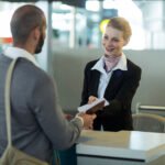 Hôtesse d'accueil portant un costume noir brodé avec le logo de l'entreprise