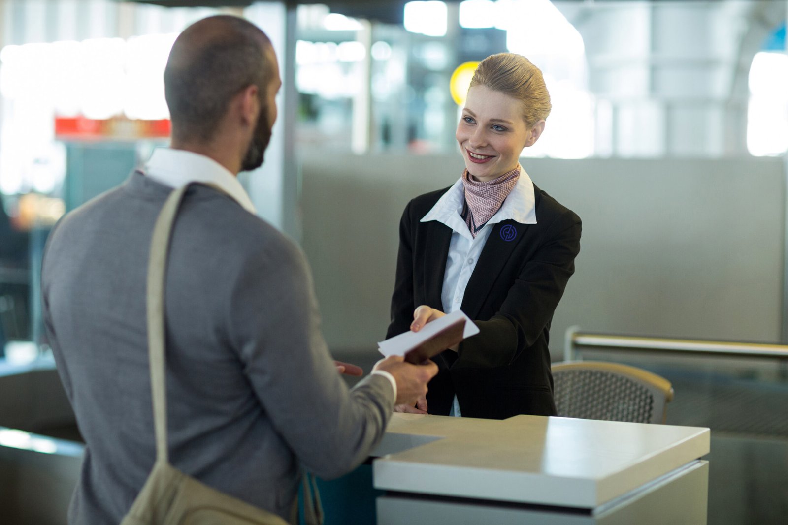 Hôtesse d'accueil portant un costume noir brodé avec le logo de l'entreprise