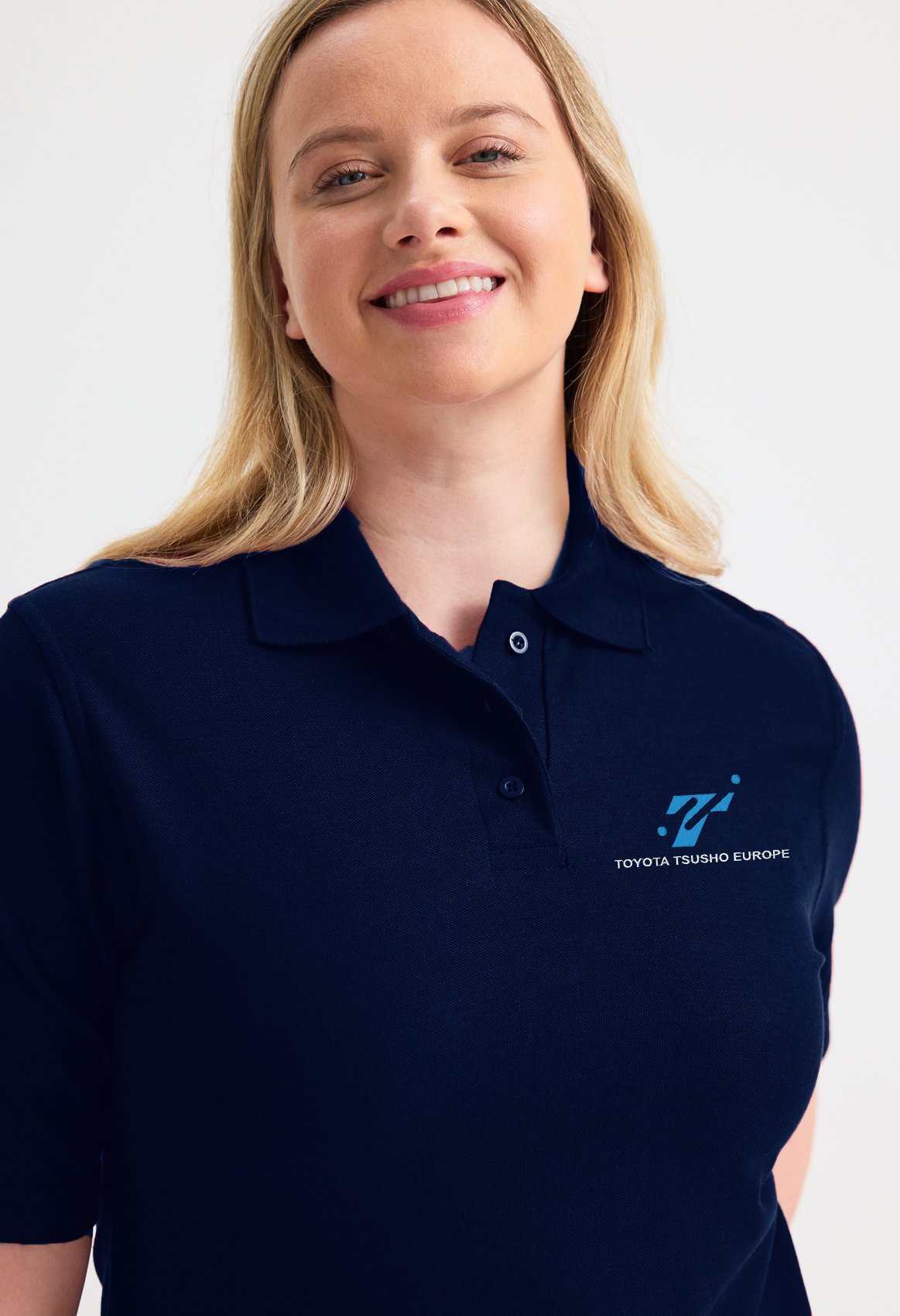 Collaborateur Toyota Tsusho portant un polo femme bleu marine brodé avec le logo de l'entreprise sur le coeur comme vêtements personnalisés pour événements d’entreprise